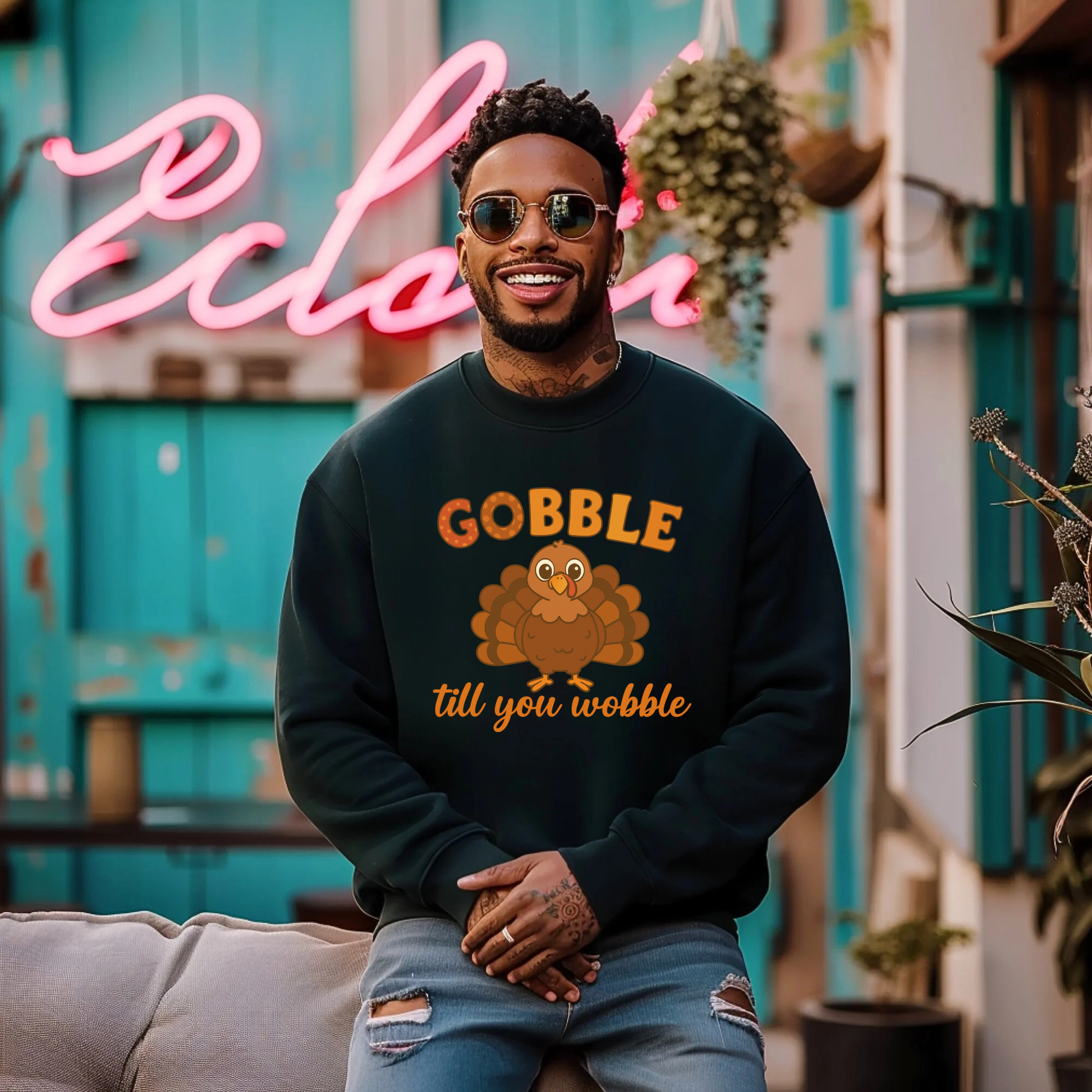 Man wearing a black sweatshirt with a turkey graphic and text, sitting in front of a colorful background.