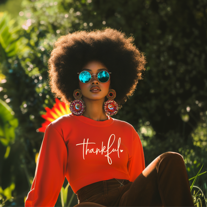 Woman wearing a red 'thankful' sweatshirt in a natural setting